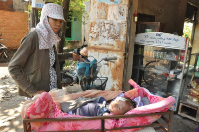 Sau khi bị chính quyền thu giữ lồng sắt, Nguyệt cho hàn chiếc khung sắt để chở bé Quý đi bán vé số Sau khi bị chính quyền thu giữ lồng sắt, Nguyệt cho hàn chiếc khung sắt để chở bé Quý đi bán vé số