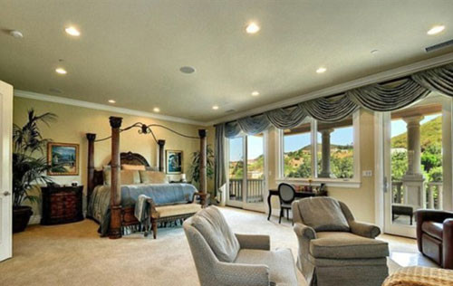 Phòng ngủ chính với cửa sổ lớn hướng ra ngoài ngọn đồi rộng lớn.