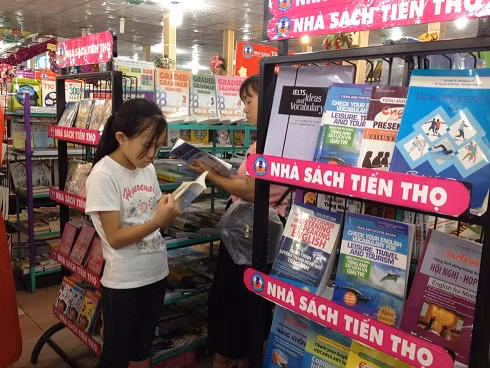 Phụ huynh đưa con đi mua sách tham khảo (Ảnh: Nguyễn Huyền).