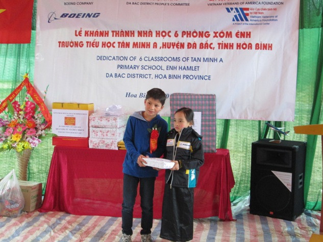 Bạn Liam Griffiths, đại diện cho học sinh Hà Nội trao quà cho các bạn học sinh trường Tân Minh A.