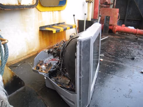 Một chiếc tivi bị đập phá tan tành nằm chỏng chơ trên boong.