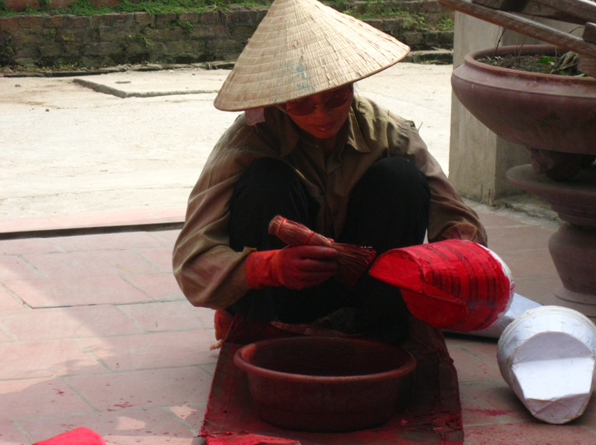 Người dân quét phẩm màu lên những sản phẩm mũ ông công ông táo.