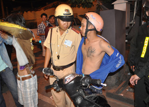 Hai thanh niên xăm trổ đầy mình mang dao bị kiểm tra và bàn giao công an phường xác minh.