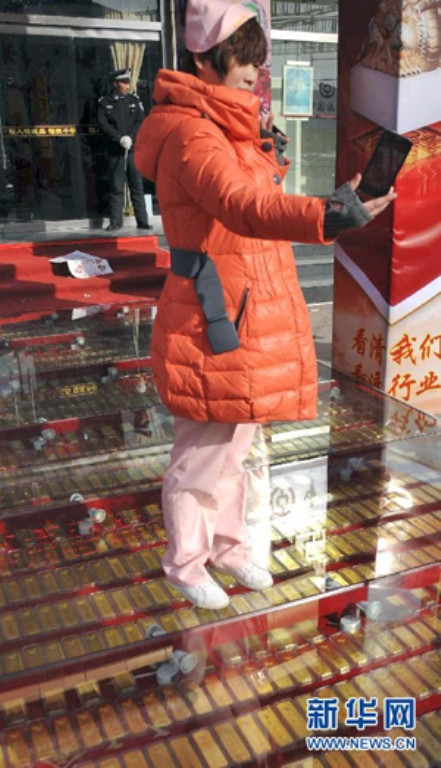 Mọi người tranh thủ chụp ảnh tại hàng vàng. Ảnh: Xinhua