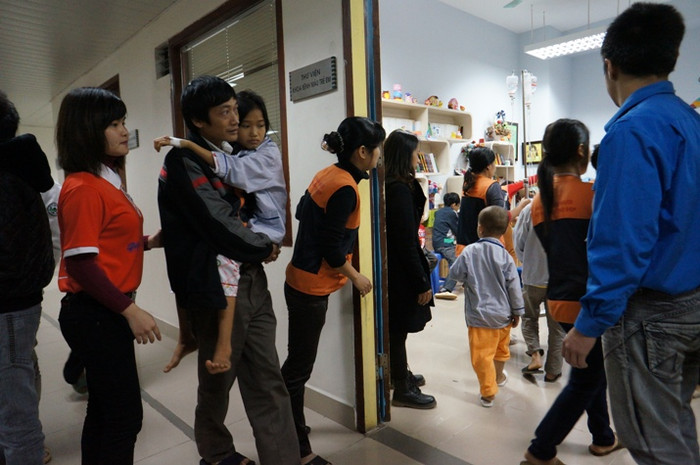 Một em gái tuy rất mệt, nhưng được bố bế tới nhận quà.