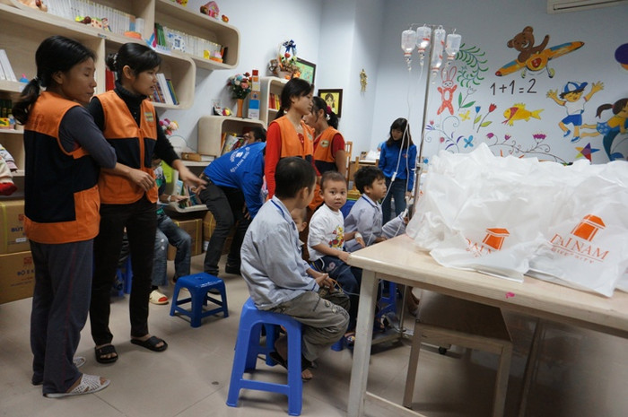 Rất nhiều em nhỏ mang theo lọ nước chuyền tới nhận quà.