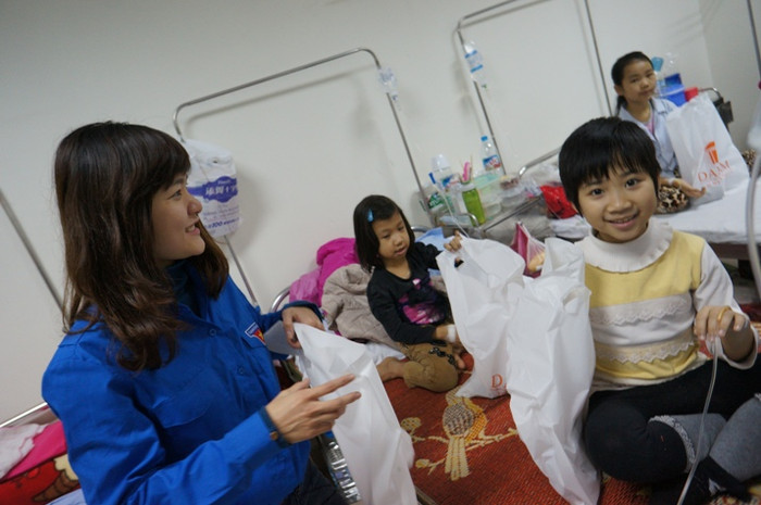 Dù đang chuyền nước, nhưng bé vẫn tươi cười khi được nhận quà.