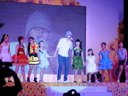 Wanbi nắm tay các em thiếu nhi và cùng cất vang giọng ca trong bài hát Cảm ơn do chính anh sáng tác. Wanbi nắm tay các em thiếu nhi và cùng cất vang giọng ca trong bài hát Cảm ơn do chính anh sáng tác.