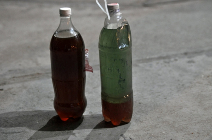 Tại hiện trường, có một số chai loại 1,5 lít chứa đầy hai phần dung dịch khác màu: phần màu xanh là xăng nguyên chất nổi phía trên, còn dung dịch màu nâu chìm xuống dưới và có thể phân biệt rõ giữa hai chất này. Chất màu nâu khi tách ra có mùi hơi giống dầu hỏa, nhưng nặng mùi hơn và khá loãng. (Nguồn vietQ) Tại hiện trường, có một số chai loại 1,5 lít chứa đầy hai phần dung dịch khác màu: phần màu xanh là xăng nguyên chất nổi phía trên, còn dung dịch màu nâu chìm xuống dưới và có thể phân biệt rõ giữa hai chất này. Chất màu nâu khi tách ra có mùi hơi giống dầu hỏa, nhưng nặng mùi hơn và khá loãng. (Nguồn vietQ)