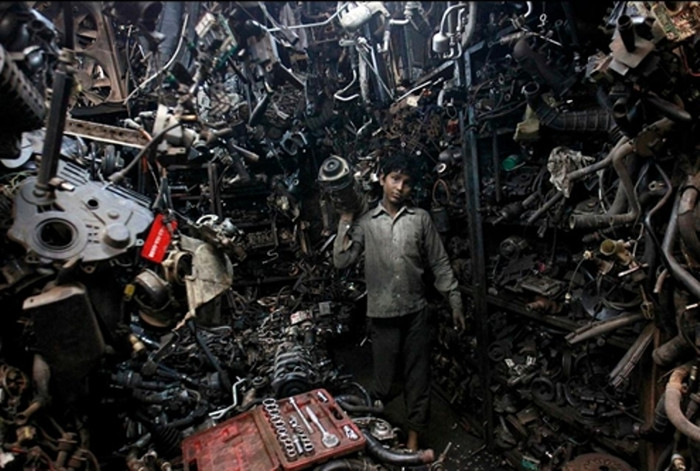 Cậu bé Abdul Samad (13 tuổi) đang vác một động cơ cũ trong xưởng ôtô ở Mumbai (Ấn Độ). Kinh tế đói kém đã đẩy hàng chục triệu trẻ em nước này vào cảnh lao động khổ sai trong các nhà máy, xí nghiệp với mức lương rẻ mạt. (Ảnh: WSJ) Cậu bé Abdul Samad (13 tuổi) đang vác một động cơ cũ trong xưởng ôtô ở Mumbai (Ấn Độ). Kinh tế đói kém đã đẩy hàng chục triệu trẻ em nước này vào cảnh lao động khổ sai trong các nhà máy, xí nghiệp với mức lương rẻ mạt. (Ảnh: WSJ)