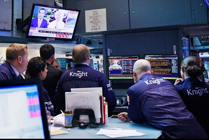 Các giao dịch viên của Knight Capital theo dõi cuộc phỏng vấn của đài truyền hình với CEO Thomas Joyce hồi tháng 8. Knight đã phải huy động thêm vốn sau khi sự cố kỹ thuật tại NYSE khiến công ty này thiệt hại tới 440 triệu USD và làm giá cổ phiếu giảm hơn một nửa. (Ảnh: Wall Street Journal) Các giao dịch viên của Knight Capital theo dõi cuộc phỏng vấn của đài truyền hình với CEO Thomas Joyce hồi tháng 8. Knight đã phải huy động thêm vốn sau khi sự cố kỹ thuật tại NYSE khiến công ty này thiệt hại tới 440 triệu USD và làm giá cổ phiếu giảm hơn một nửa. (Ảnh: Wall Street Journal)