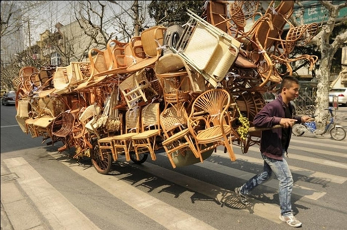 Một người đàn ông kéo chiếc xe chở đầy ghế mây trên đường phố Thượng Hải. (Ảnh: AFP) Một người đàn ông kéo chiếc xe chở đầy ghế mây trên đường phố Thượng Hải. (Ảnh: AFP)