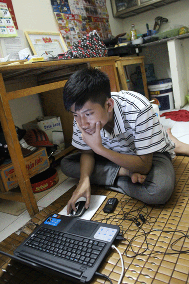 Thủ khoa Nguyễn Hữu Tiến với chiếc máy tính xách tay vừa được nhà hảo tâm tặng. Kế hoạch của chàng trai là sẽ đưa xe đạp lên Hà Nội để đi học và đi dạy thêm kiếm tiền phụ giúp bố mẹ. Ảnh: Bình Minh.