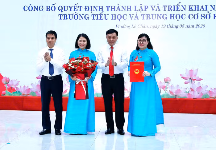 Lãnh đạo phường Lê Chân trao quyết định và tặng hoa chúc mừng nhà trường.