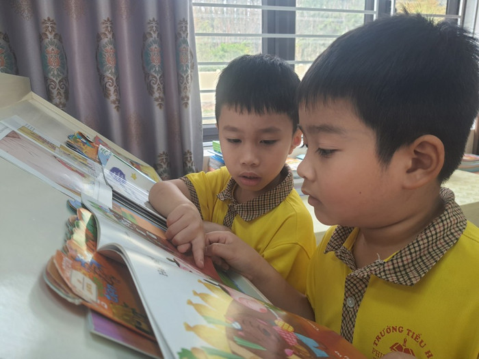 Các em học sinh lớp 1A1 say sưa đọc sách tại thư viện. Ảnh: CTV co-giao-hoa-qn-2.jpg