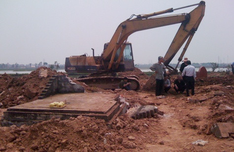 Chiếc máy xúc bị lập biên bản ngày 1/4 khi làm vỡ, sụp bia mộ phần mộ của bố đẻ ông Lan. (ảnh người dân cung cấp)