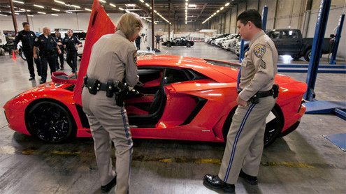 Hai thành viên của Cảnh sát giao thông California kiểm tra số xe của một chiếc Lamborghini Aventador LP700-4 2012. Những chiếc xe đắt tiền bị phát hiện khi chúng đã rời khỏi bến bốc dỡ với hóa đơn kê khai là "thiết bị tập luyện thể thao". Hai thành viên của Cảnh sát giao thông California kiểm tra số xe của một chiếc Lamborghini Aventador LP700-4 2012. Những chiếc xe đắt tiền bị phát hiện khi chúng đã rời khỏi bến bốc dỡ với hóa đơn kê khai là "thiết bị tập luyện thể thao".