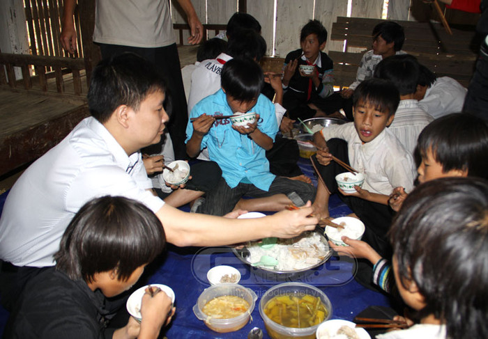 Tổng biên tập Nguyễn Tiến Bình gắp từng miếng thịt cho các em HS Tổng biên tập Nguyễn Tiến Bình gắp từng miếng thịt cho các em HS