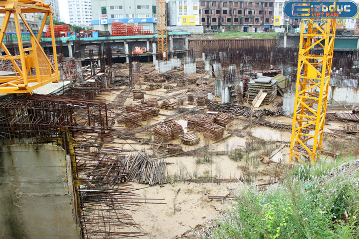 Lòng công trường ngổn ngang giàn giáo, sắt thép hoen rỉ.