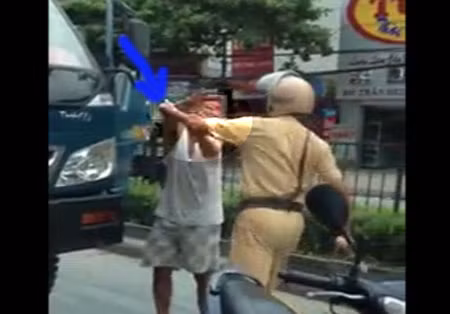 Người mặc sắc phục CSGT liên tiếp ra đòn về lái xe. (ảnh cắt từ video)