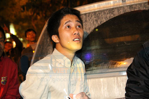 Anh Nguyễn Huy Học kinh hãi kể lại sự việc và không ngừng nhìn về tầng thượng, nơi còn những công nhân đang mắc kẹt. (Ảnh NP)