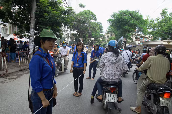 Trong buổi sáng nay, lực lượng SVTN tại nhiều điểm dự thi đã phải dàn hàng dọc cầm tay nhau, dùng dây thừng để căng đường chia làn nhằm giảm ùn tắc giao thông.