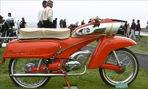 DKM Hummel 155 1965: Có thể dễ dàng nhận thấy, Hummel DKM 155 có kiểu dáng hoàn toàn khác với những chiếc xe đang lưu thông hiện nay, thậm chí vào năm 1965 nó cũng hoàn toàn khác biệt với những chiếc xế nổ khác. Thời điểm đó, các bài báo tại châu Âu đã đặt cho DKM 155 tên gọi rất thú vị “Tin banana” (quả chuối thiếc). DKM 155 được trang bị khối động cơ 50cc, công suất 4,2 mã lực, giúp xe đạt vận tốc tối đa 72 km/h, kèm theo đó là sự xuất hiện của hộp số 3 cấp hoàn toàn mới.