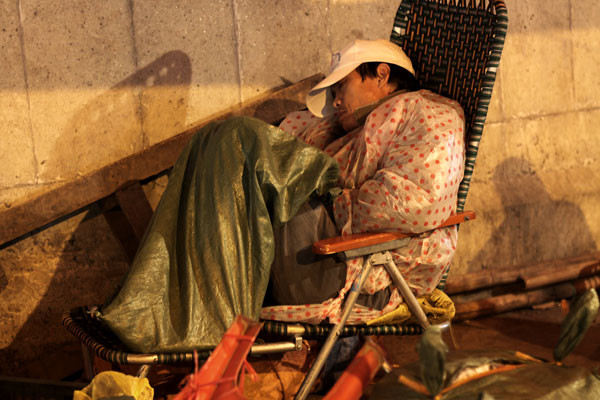 Áo mưa vẫn chưa đủ ấm, người đàn ông này phải dùng.... bao tải để ủ ấm trong đêm lạnh.