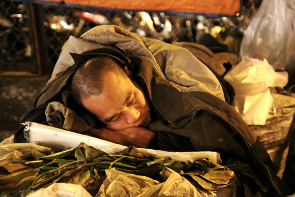 Tranh thủ ngủ ngay trên những sọt ổi, đắp lên mình đủ thứ áo khoác, áo mưa.