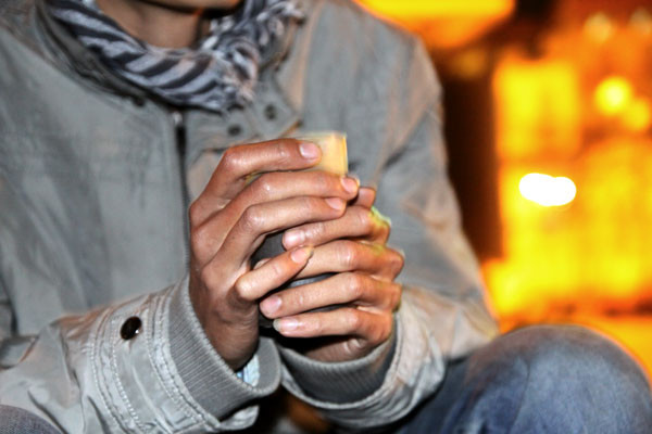 Hai tay cầm chặt cốc nước nóng ngắm phố đêm đông.