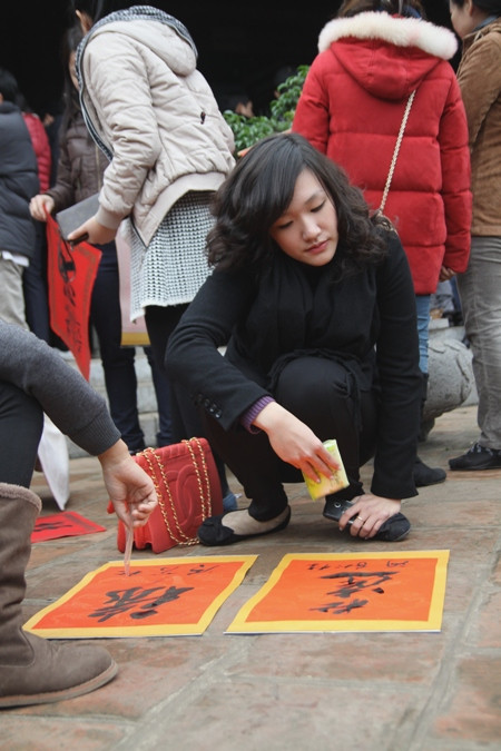 Một bạn trẻ sau khi xin được chữ thì đem phơi ở sân và dùng.... gói giấy để quạt cho chữ mau khô. Một bạn trẻ sau khi xin được chữ thì đem phơi ở sân và dùng.... gói giấy để quạt cho chữ mau khô.