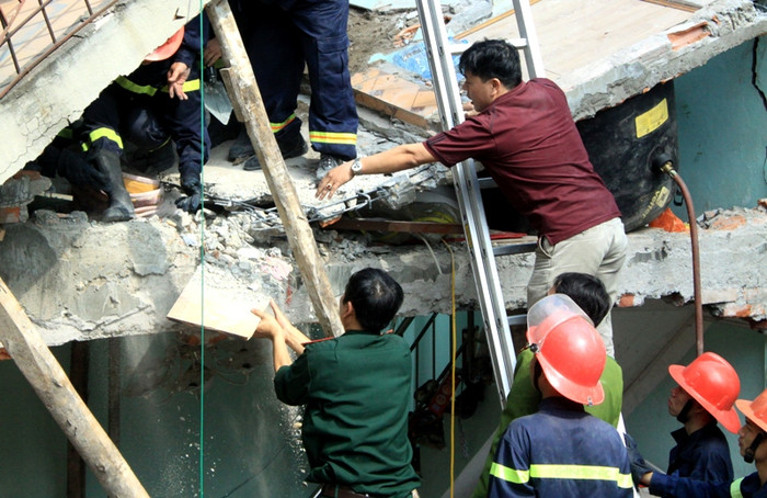 Nhẹ nhàng gỡ từng tấm gỗ, viên gạch nơi xác định là hai cháu nhỏ nằm tại góc sàng tầng 2. Nhẹ nhàng gỡ từng tấm gỗ, viên gạch nơi xác định là hai cháu nhỏ nằm tại góc sàng tầng 2.