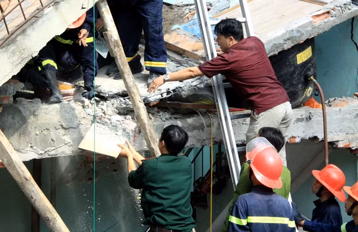 Nhẹ nhàng gỡ từng tấm gỗ, viên gạch nơi xác định là hai cháu nhỏ nằm tại góc sàng tầng 2.