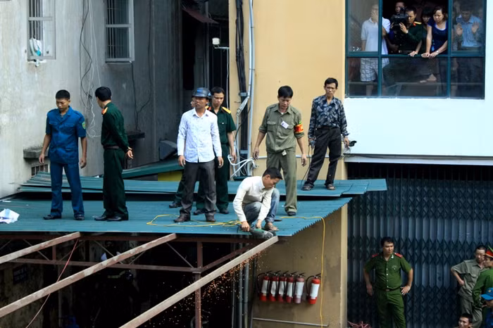 Mái tôn nhà xe đằng sau tòa nhà chung cư được phá bỏ phục vụ công tác cứu hộ.