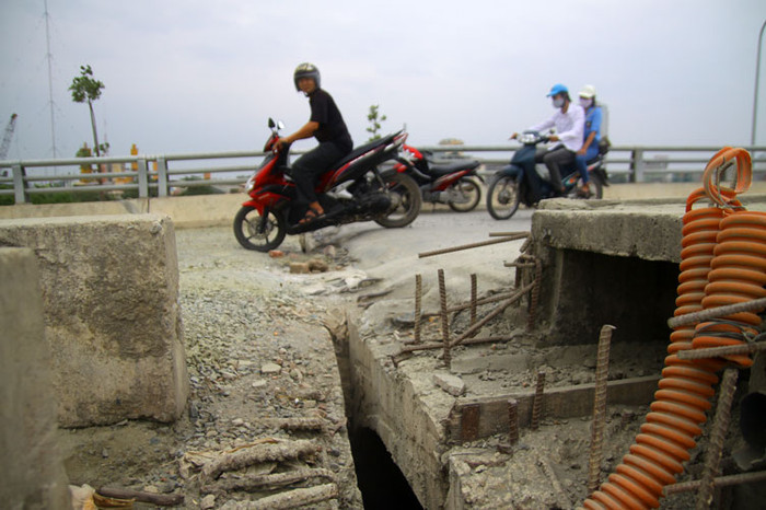 Để có thể qua lại trên những cây cầu này, người dân phải san lấp các khe hở rộng cả gang tay và chơ sắt mới đi lại được.