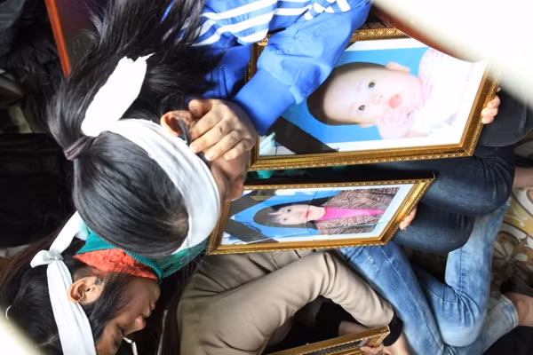 Thân nhân các bị hại ôm di ảnh các nạn nhân
