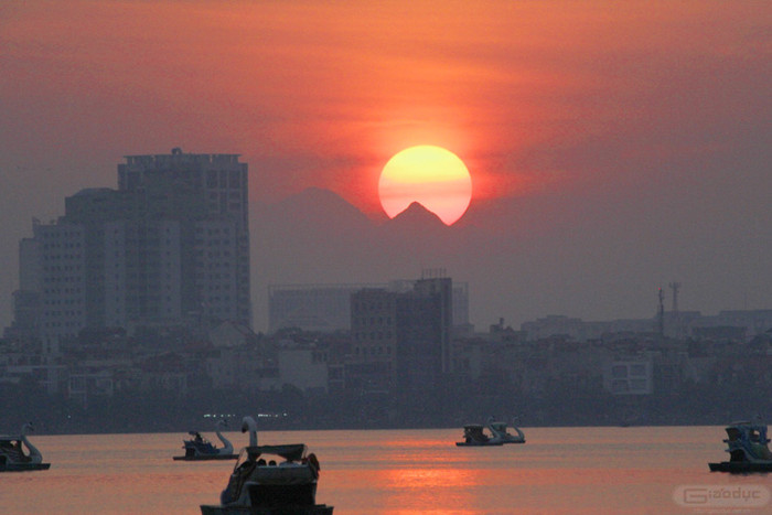Hoàng hôn xuống, mặt hồ nhẹ lay, in bóng mặt trời đang dần xuống sau dãy núi Tản. Hoàng hôn xuống, mặt hồ nhẹ lay, in bóng mặt trời đang dần xuống sau dãy núi Tản.