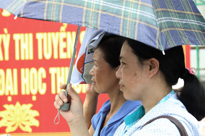 Dù mưa hay nắng, các bậc phụ huynh sau khi đưa con em mình tới điểm thi, dù trong bộ dạng áo mưa hay che ô tránh nắng thì những cặp mắt của họ vẫn đăm đăm nhìn vào phía bên trong cổng trưởng đợi chờ từng phút để đón con. Dù mưa hay nắng, các bậc phụ huynh sau khi đưa con em mình tới điểm thi, dù trong bộ dạng áo mưa hay che ô tránh nắng thì những cặp mắt của họ vẫn đăm đăm nhìn vào phía bên trong cổng trưởng đợi chờ từng phút để đón con.