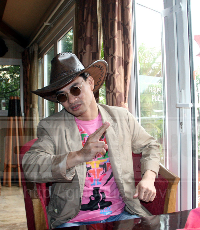 Mô tả động tác bắn súng. Chiếc áo hồng anh mặc cũng có khá nhiều... súng.