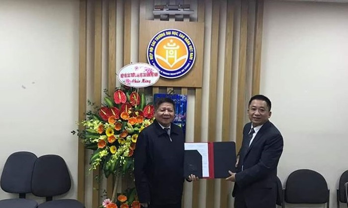 Phó giáo sư - Tiến sĩ Trần Xuân Nhĩ trao Quyết định thành lập Viện Truyền thông và Phát triển nhân lực cho Viện trưởng.