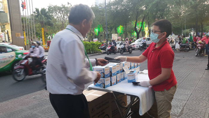 Cậu bé Andy đứng phát khẩu trang miễn phí cho người dân (Ảnh:NVCC) Cậu bé Andy đứng phát khẩu trang miễn phí cho người dân (Ảnh:NVCC)