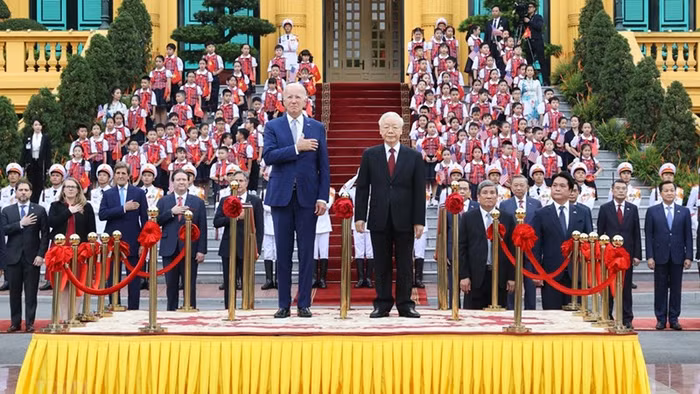Tổng Bí thư Nguyễn Phú Trọng và Tổng thống Hoa Kỳ Joe Biden trên bục danh dự, thực hiện nghi thức chào cờ. (Ảnh: TTXVN)
