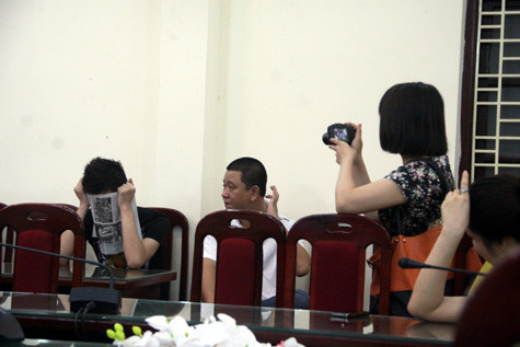 Kiên "pê đê" lấy báo che mặt khi Pv chụp hình. Ảnh: Văn Trinh