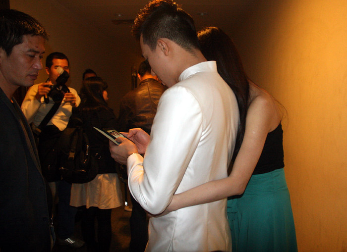 Người yêu nhẹ nhàng ôm Trấn Thành từ phía sau, mặc ống kính máy ảnh chĩa vào.