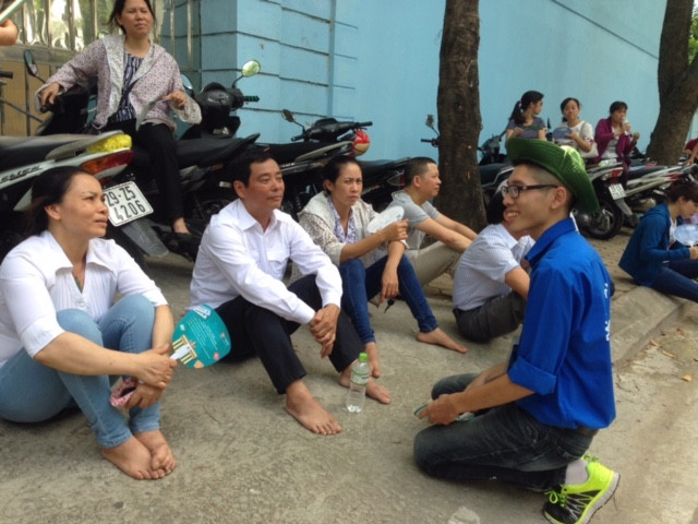 Bạn Nguyễn Đăng Thái Hoàng (sinh viên khoa Y dược Đại học Quốc gia Hà Nội) nhiệt tình mang nước uống cho các phụ huynh và trò chuyện về những lưu ý về quy chế thi năm nay.
