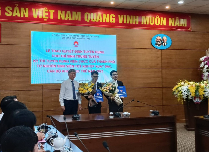 Giám đốc Sở Giáo dục và Đào tạo Thành phố Hồ Chí Minh trao quyết định tuyển dụng cho hai sinh viên xuất sắc (ảnh: V.D)