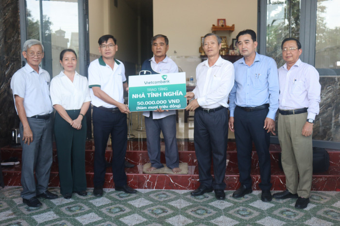 Ông Bùi Hoàng Anh - Chủ tịch Công đoàn cơ sở, Phó Giám đốc Vietcombank Bình Thuận (thứ 3 từ phải sang) cùng lãnh đạo địa phương bàn giao nhà tình nghĩa cho hộ ông Lại Văn Năm.