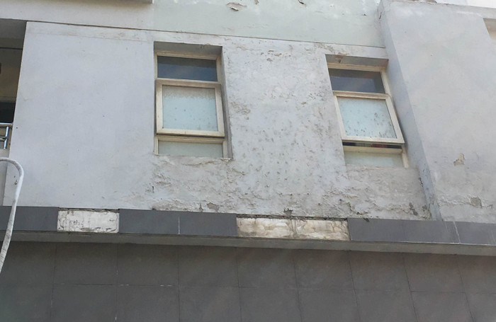 Gạch ốp tường một số tòa nhà rơi xuống rất nguy hiểm. Ảnh: Vũ Phương.