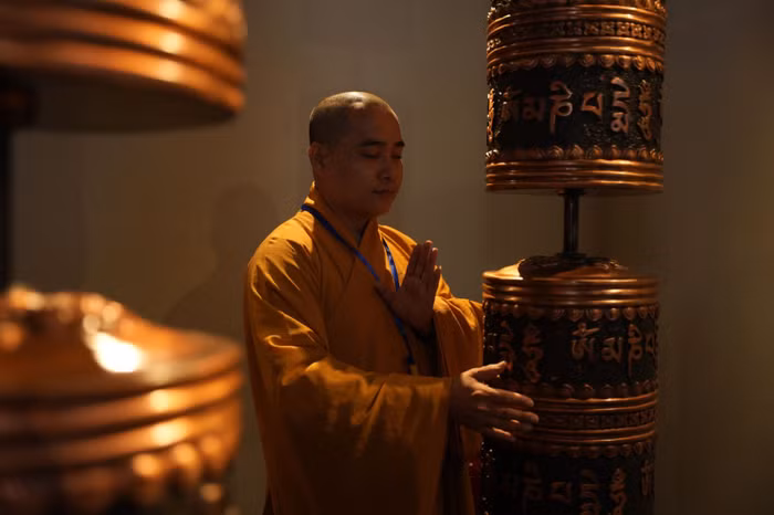 Các tăng ni sư cầu nguyện và xoay bánh xe Kinh Luân tại tầng hai của khu triển lãm Phật giáo dưới chân đại tượng Phật Bà Tây Bổ Đà Sơn trên đỉnh núi. Đây là một loại pháp khí được tín đồ Phật giáo Tây Tạng sử dụng cho việc hành trì tụng niệm. Người ta tin rằng, bánh xe Kinh Luân có thể quay như một cách tạo công đức vô lượng một cách đơn giản nhất, chỉ cần chạm vào bánh xe cầu nguyện đã là một sự tịnh hóa to lớn trong việc xóa bỏ nghiệp chướng. Ảnh: Sun World Ba Den Mountain