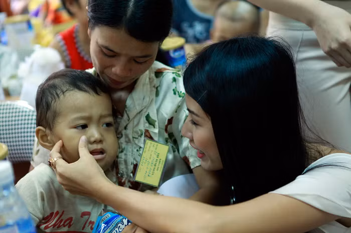 Cô dịu dàng hỏi han một em bé.